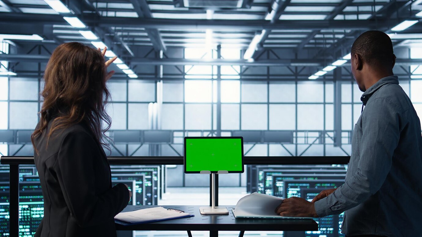 Engineers in server room checking devices.